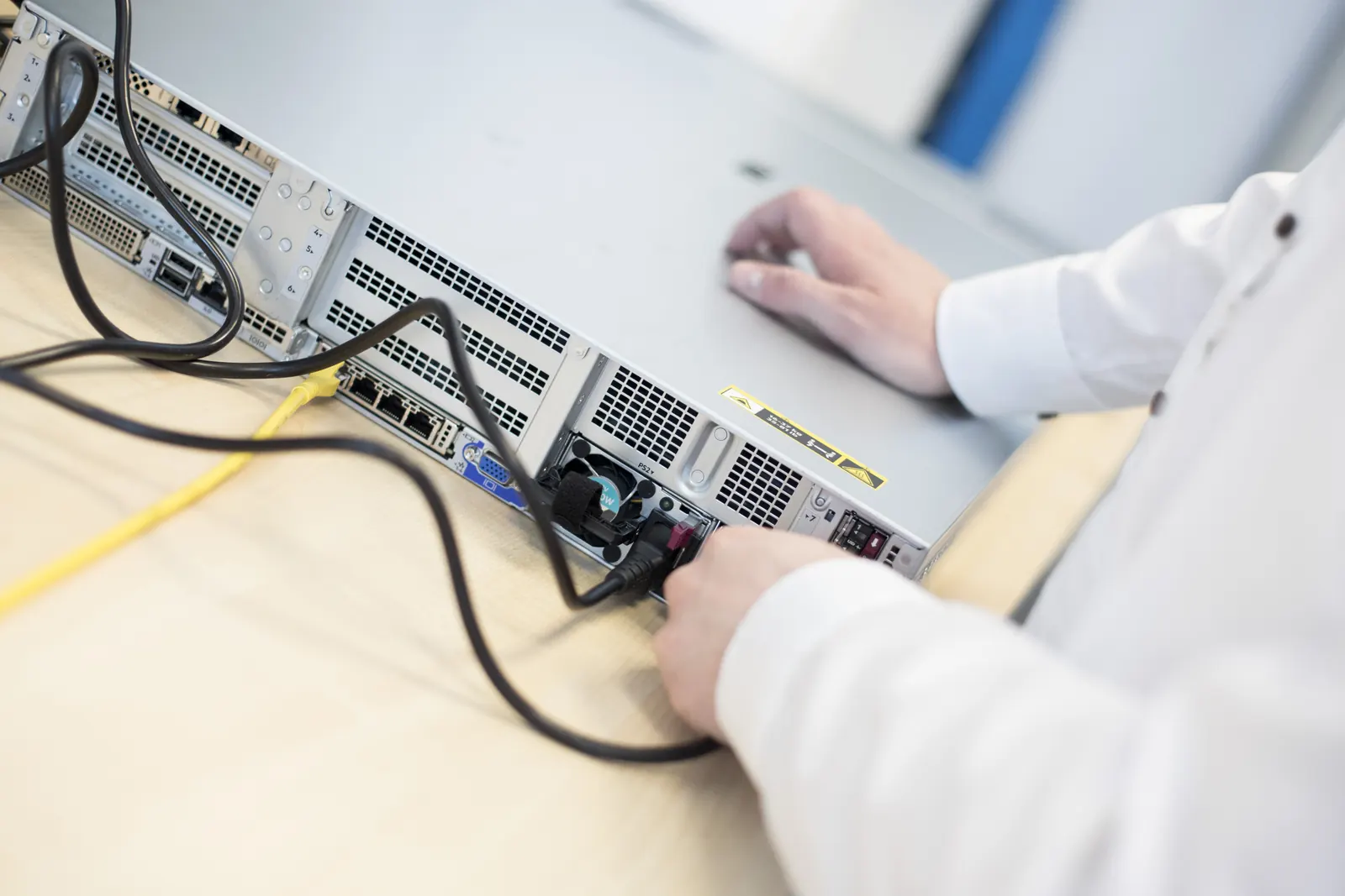 Kabel werden an der Rückseite eines Rack-Servers gesteckt