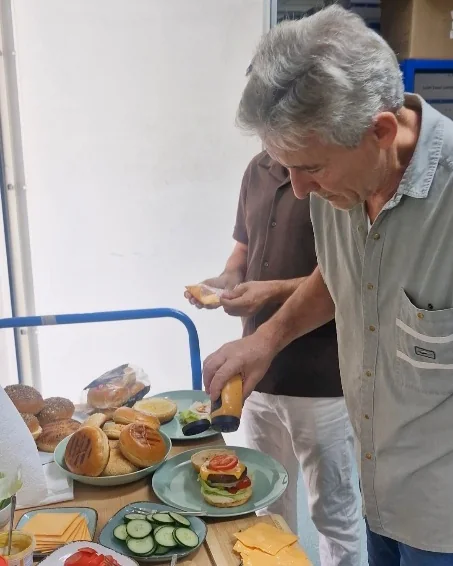 Ein Kollege belegt die Burger am Buffet